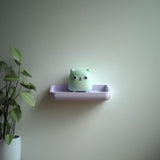 3D printed Cube Cat Wall Shelf with small cube cat character sitting in a rounded tray like ledge
