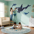 Realistic illustration of a large black and white orca swimming with two grey dolphins and two blue whales.