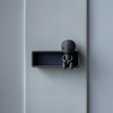 3D printed Grim Stitch Doll Wall Shelf with integrated stitched doll figure sitting on the edge against a light wall