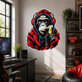 Red hoodie gorilla wearing headphones wall sticker above a black desk and monitor in a gaming room.