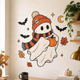 Cute Halloween ghost wall decal wearing an orange beanie and striped scarf, holding a pumpkin among bats, stars and leaves.