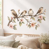 Watercolor wall sticker of four small brown and cream birds on a branch with pink blossoms and green leaves.