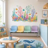 Colorful coral reef and tropical fish wall decal above a children's play table with blue chairs.