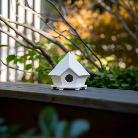 3D printed geometric birdhouse ornament featuring a faceted roof and circular entrance