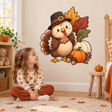 Girl sitting on a rug below a smiling Thanksgiving turkey and pumpkin wall decal.