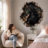 Woman seated in a pale armchair beneath a black unicorn wall decal beside a bed.