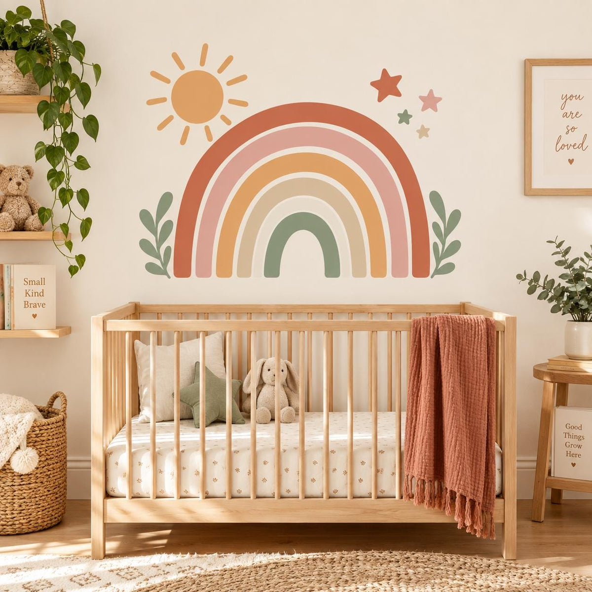 Terracotta and sage rainbow wall decal with sun and leaves above a wooden nursery crib.