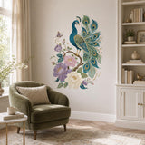 Turquoise peacock wall sticker with pink flowers above an olive armchair and white bookshelf.