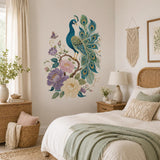Teal peacock and floral wall decal beside a white bed with a pale green blanket and bedside lamp.