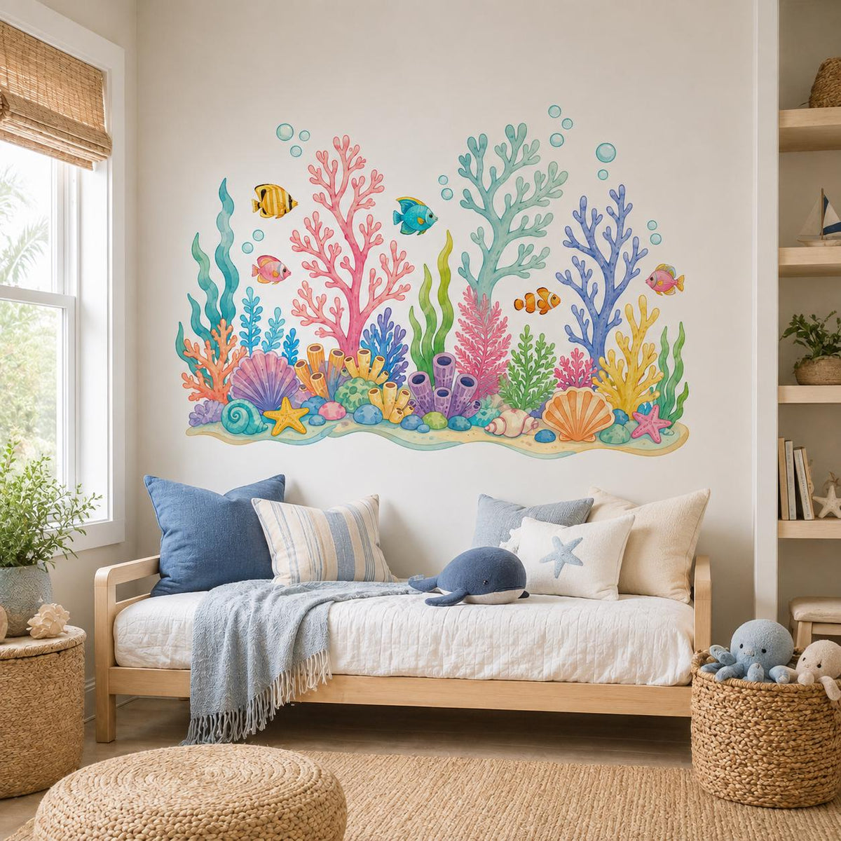 Pastel coral and sea-life wall decal over a blue children's daybed with marine pillows.