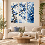 Three-panel blue blossom tree decal above a cream sofa and round wooden coffee table.