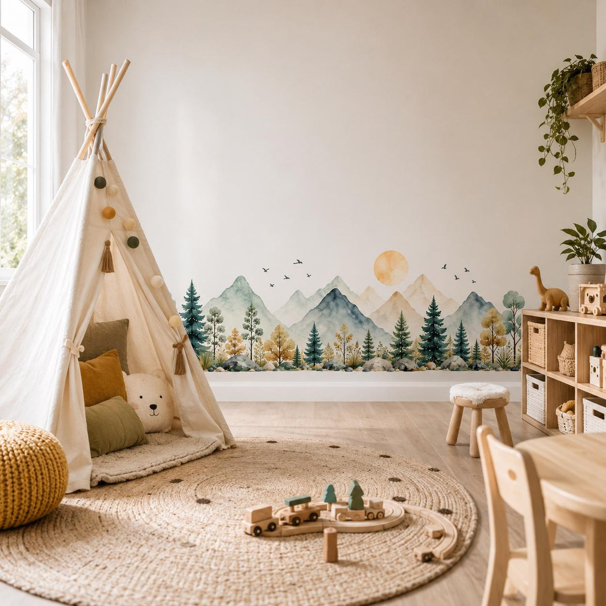 Watercolor mountain and pine forest wall decal behind a children's teepee tent and toys in a nursery.