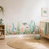 Sea turtle and coral reef wall decal along the wall beside a wooden crib in a coastal nursery.