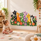 Young girl playing on a rug beneath a colorful cats and flowers wall decal.