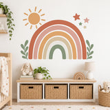 Earth-tone rainbow wall decal above a low wooden dresser in a neutral nursery.