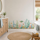 Watercolor sea turtle and seaweed wall decal in a bathroom beside a wooden vanity and white towels.