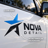 Close-up of blue and black NOVA DETAIL contour-cut vinyl logo on a white car door, showing clean edges without rectangular backing.