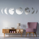 Moon phases wall decal in a modern living room decor, featuring stylish pink chair and wooden furniture.