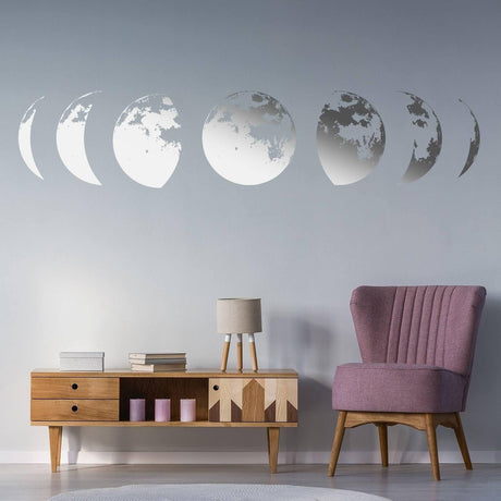 Moon phases wall decal in a modern living room decor, featuring stylish pink chair and wooden furniture.