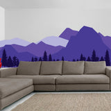 Majestic mountain wall decal in purple tones above a modern gray sofa in a stylish living room.