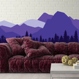 Vibrant mountain wall decal in purple tones above a cozy burgundy sofa, enhancing interior decor.
