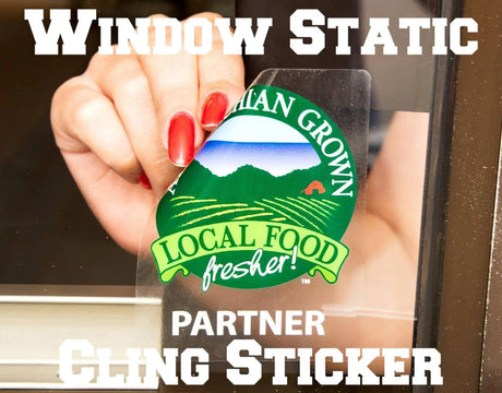 Hand applying a window static cling sticker promoting local food; easy to use and residue-free.