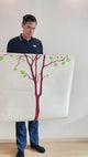 Person holding Nature's Serenity vinyl wall decal featuring a tree design, showcasing its easy installation and artistic appeal.