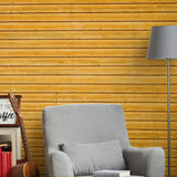 Rustic wood plank peel and stick wallpaper in a cozy living room setting with gray armchair and lamp.