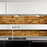 Self-stick rustic wood plank wallpaper installed in a modern kitchen backsplash above a stainless steel sink.