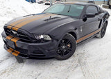 Stylish black car with gold racing stripes, showcasing two lines racing decals on snowy surface.