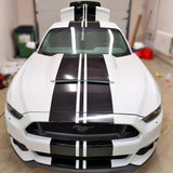 Stylish car with black racing stripes decals showcasing a sleek, upgraded look in a garage setting.