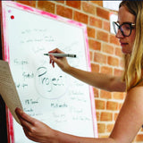Woman writing on a dry erase board with a marker, showcasing organizational project ideas.