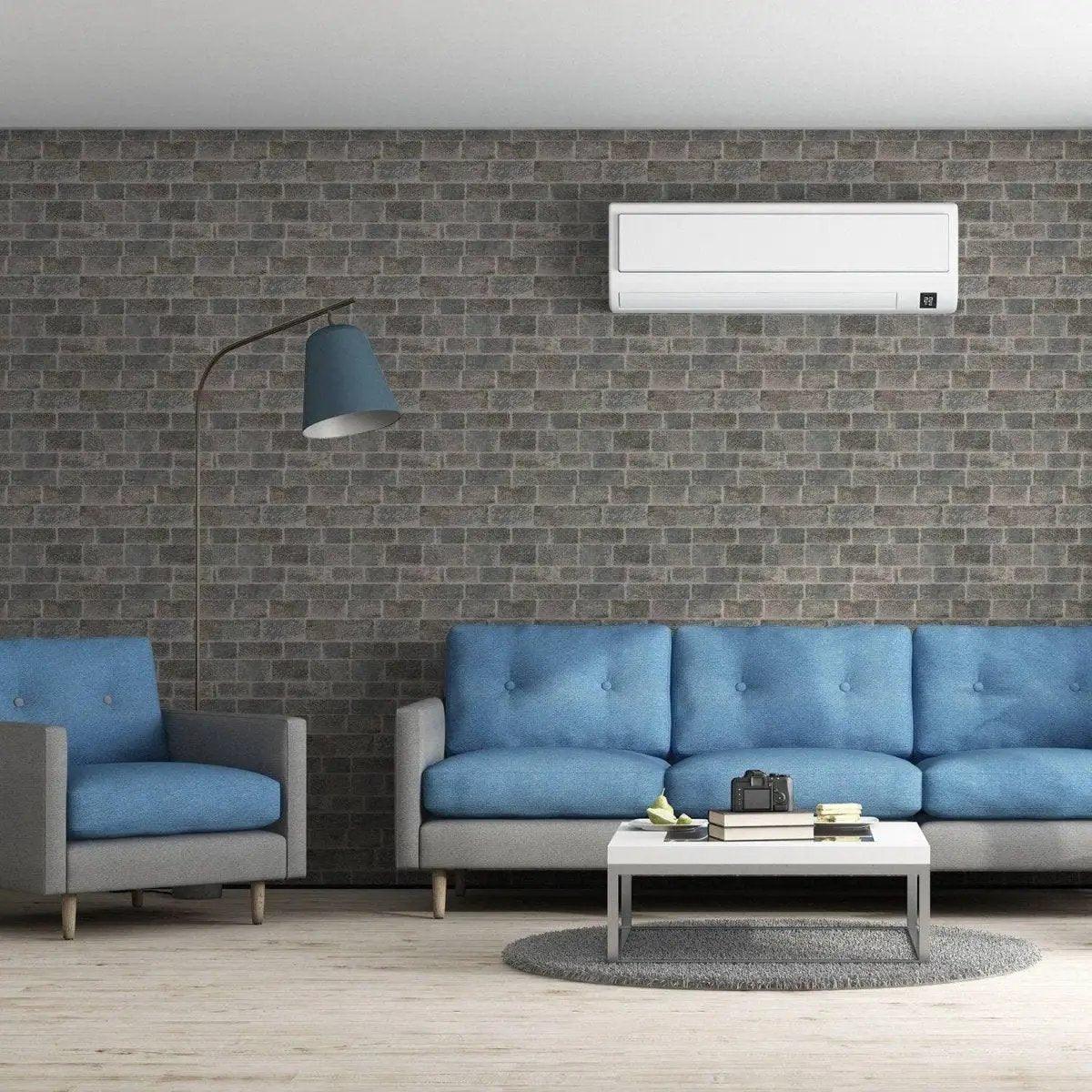 Modern living room with printed stone-and-brick-effect vinyl wallpaper, featuring blue couches and stylish decor.