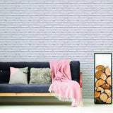 Living room featuring 3D stone wall peel and stick wallpaper with cozy sofa and decorative throw.