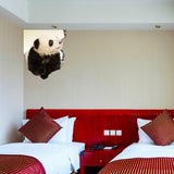 3D wildlife porthole wall decal featuring a cute panda peeking through a bedroom wall in a stylish hotel room.