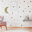 Celestial Dreams wall stickers featuring stars and moon accenting a nursery wall with a crib and cozy decor.