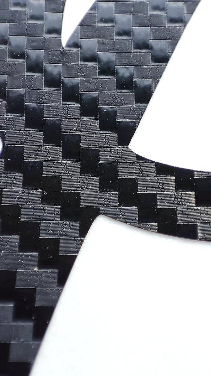 Close-up of personalized carbon fiber letter decal showcasing the textured pattern of.
