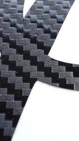 Close-up of personalized carbon fiber letter decal showcasing the textured pattern of.