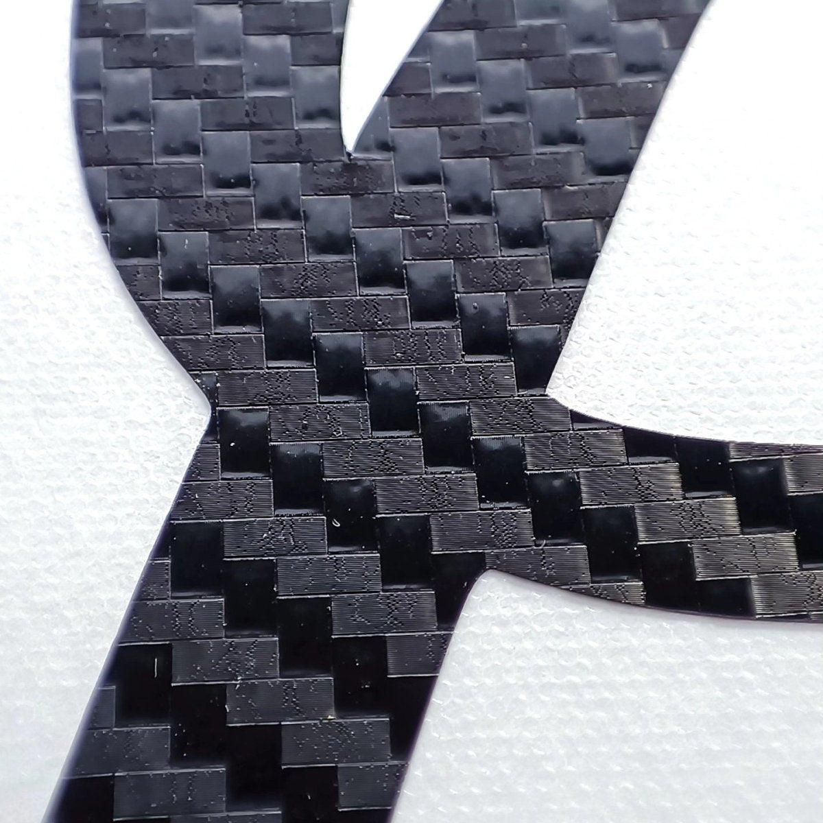 Close-up of personalized carbon fiber letter sticker showcasing a sleek.