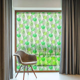Etched glass film with leaf design enhancing privacy in a bright room with a stylish chair and curtains.