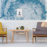 Sophisticated blue marble effect wallpaper in a modern living room with stylish chairs and a decorative table.