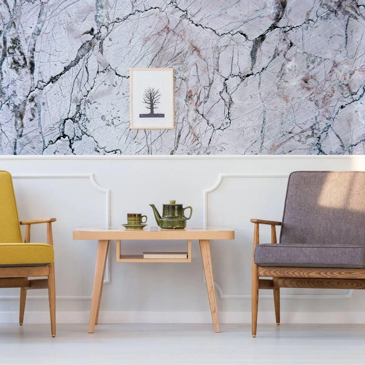Elegant marble wall covering in a modern living room with two stylish chairs and a wooden table.