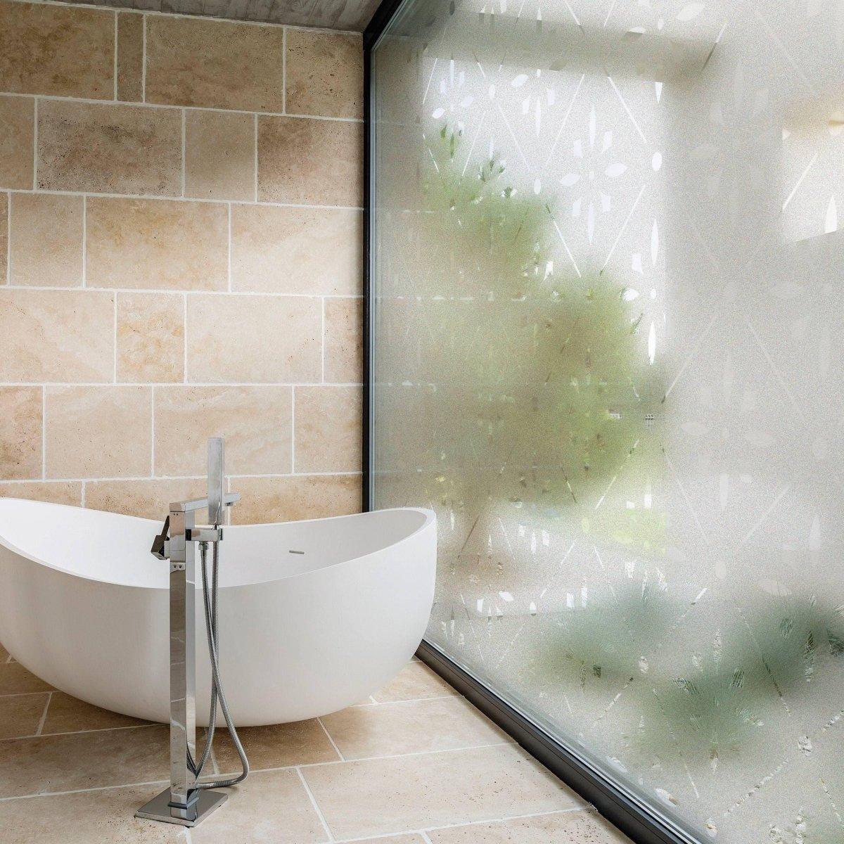Deluxe geometric frosted window decal enhancing privacy in a modern bathroom with a freestanding tub.