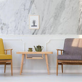 Stylish living room featuring marble-pattern wallpaper, wooden table, and modern chairs with a cozy decor.