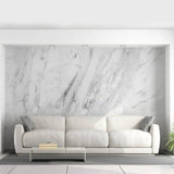 Stylish living room featuring stone-pattern adhesive wallpaper and a modern white couch with decorative pillows.