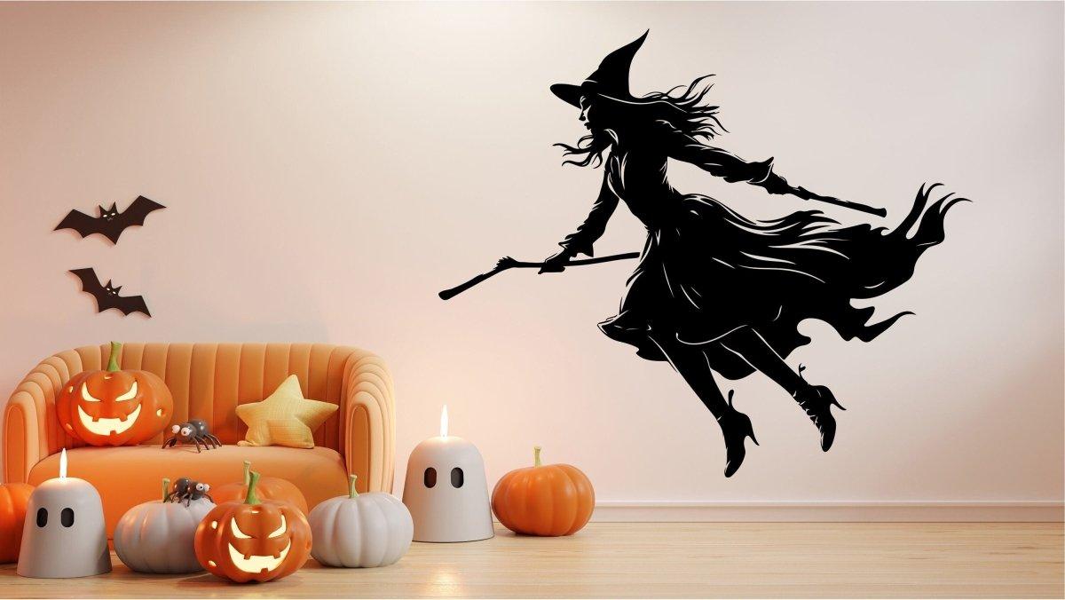 Flying broom figure silhouette wall decal displayed in a decorated room.
