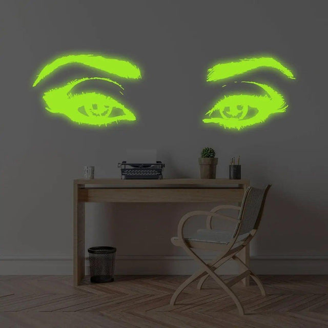 Glowing luminescent vinyl wall decal of eyes above a wooden desk, illuminating the room with enchanting light.