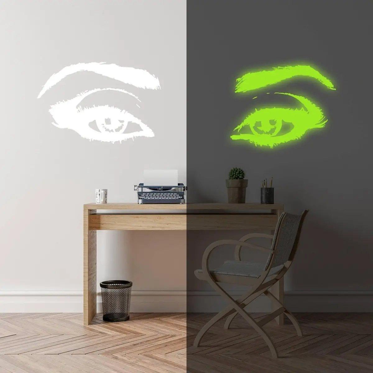 Glowing luminescent eye vinyl wall decal illuminating a workspace at night, captivating glow effect.