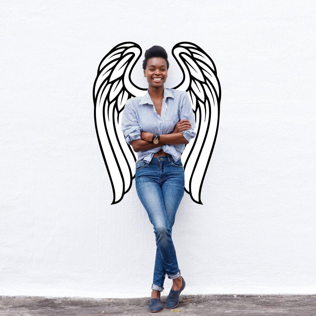 Woman smiling with angel wings wall decor in the background, showcasing a bohemian style and elegant ambiance.