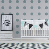 Nursery with gold circle wall decals, crib, and decorative bunting for a magical touch.